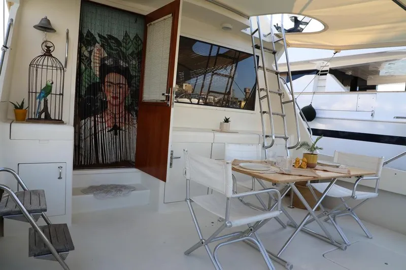  Yacht Photos Pics 1989 Hatteras 58 yacht interior with dining area, ladder, and decorative elements.