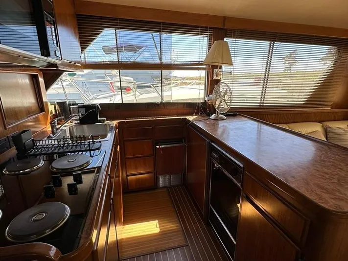  Yacht Photos Pics Interior of 1989 Hatteras 58 yacht kitchen with wooden cabinetry and appliances.