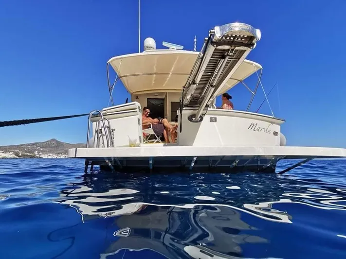  Yacht Photos Pics 1989 Hatteras 58 yacht on blue water, people relaxing on deck.