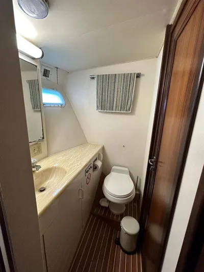  Yacht Photos Pics 1989 Hatteras 58 yacht bathroom with sink, toilet, and striped curtain.