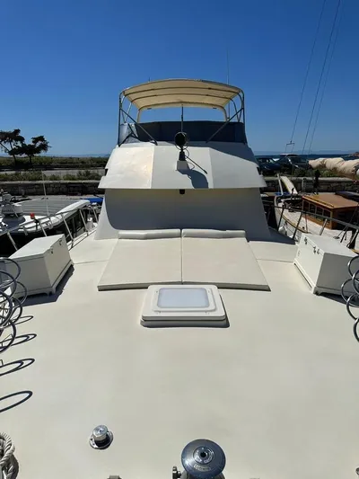  Yacht Photos Pics 1989 Hatteras 58 yacht with spacious deck and canopy under clear blue sky.