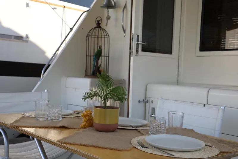  Yacht Photos Pics Dining setup on 1989 Hatteras 58 yacht with potted plant and birdcage decor.