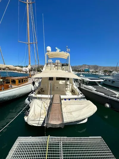  Yacht Photos Pics 1989 Hatteras 58 yacht docked at marina under clear blue sky.