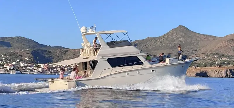  Yacht Photos Pics 1989 Hatteras 58 yacht cruising on calm waters with scenic mountain backdrop.