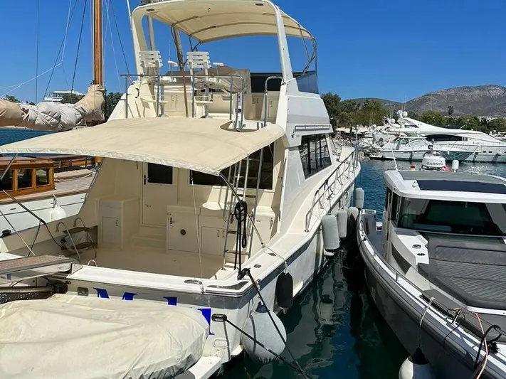  Yacht Photos Pics 1989 Hatteras 58 yacht docked in a sunny marina, surrounded by other boats.