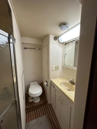  Yacht Photos Pics Bathroom interior of 1989 Hatteras 58 yacht, featuring toilet, sink, and shower.