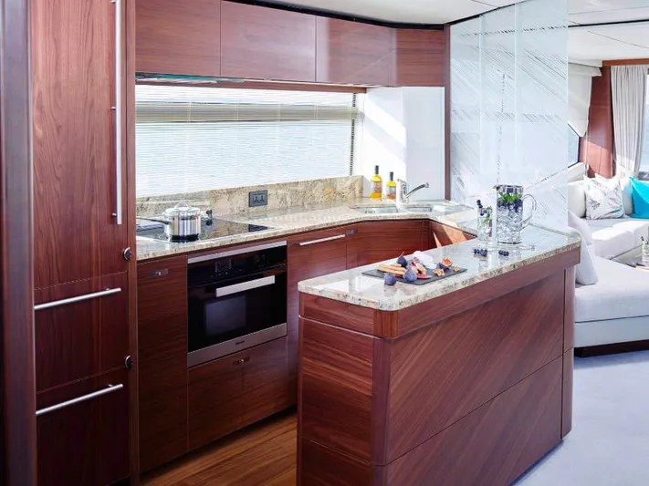  Yacht Photos Pics Luxurious kitchen interior on a 2019 Princess 75 yacht, featuring modern appliances and elegant wood finishes.
