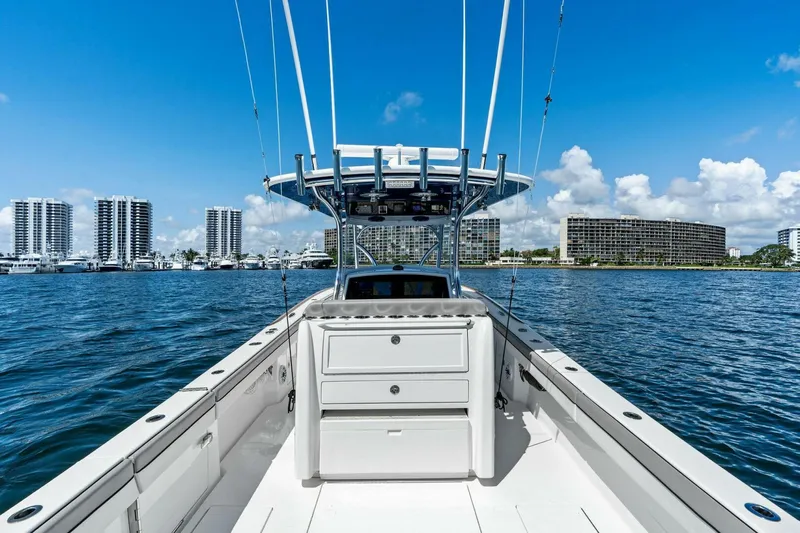 Lily Yacht Photos Pics 2021 Valhalla Boatworks V-33 on water, city skyline in background, clear blue sky.