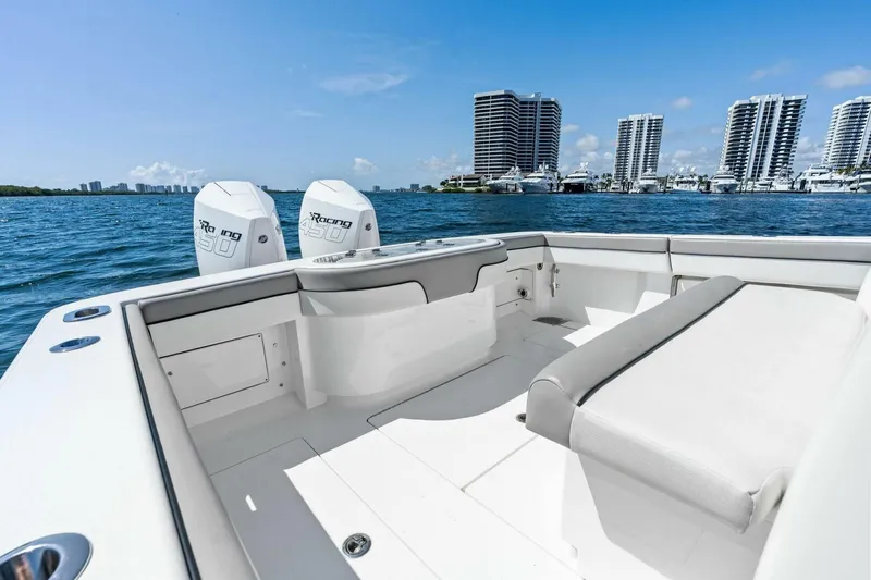 Lily Yacht Photos Pics 2021 Valhalla Boatworks V-33 on water, city skyline in background, sunny day.
