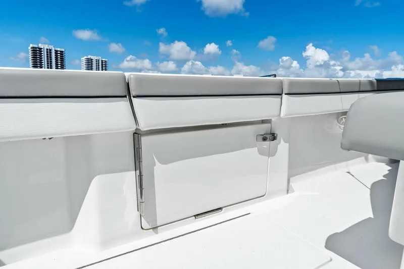 Lily Yacht Photos Pics 2021 Valhalla Boatworks V-33 interior with sleek white seating and storage, under a clear blue sky.