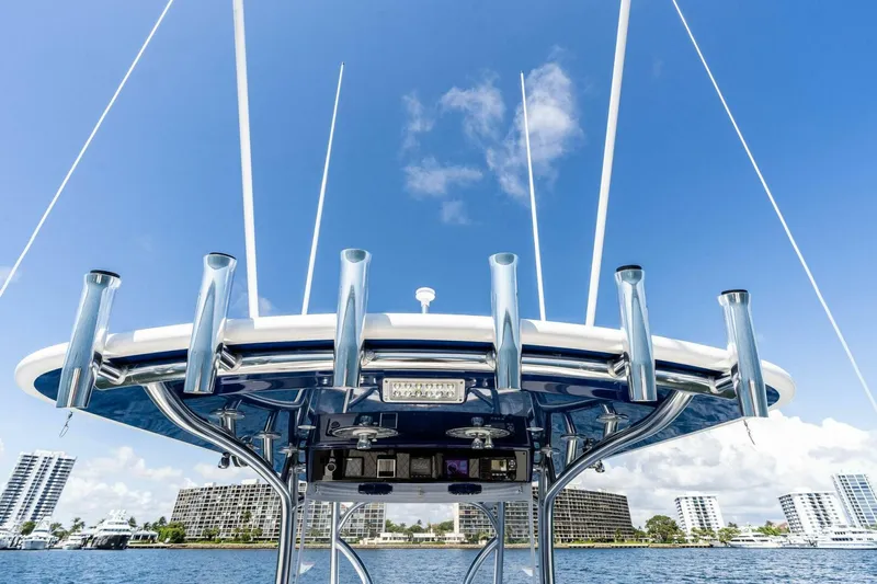 Lily Yacht Photos Pics 2021 Valhalla Boatworks V-33 with rod holders, blue sky, and waterfront cityscape.