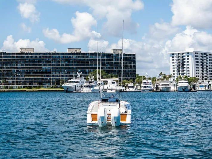 Lily Yacht Photos Pics 2021 Valhalla Boatworks V-33 on water, cityscape and yachts in background.