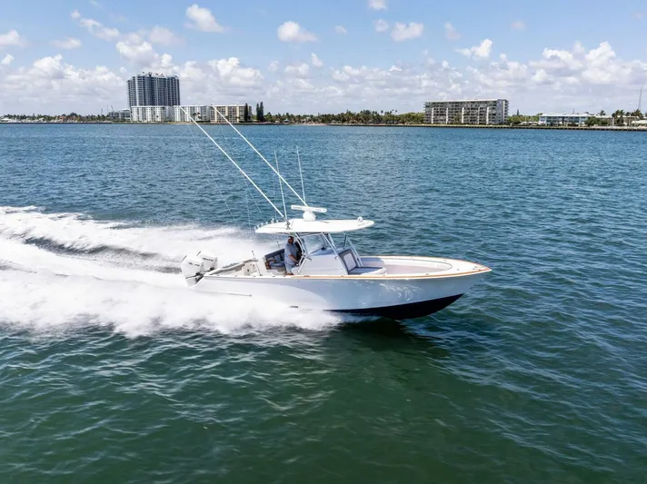 Lily Yacht Photos Pics 2021 Valhalla Boatworks V-33 cruising on open water, cityscape in background.
