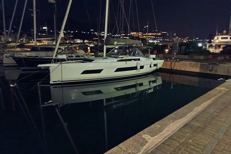  Yacht Photos Pics 2024 Dufour 44 yacht docked at night, reflecting on calm water.