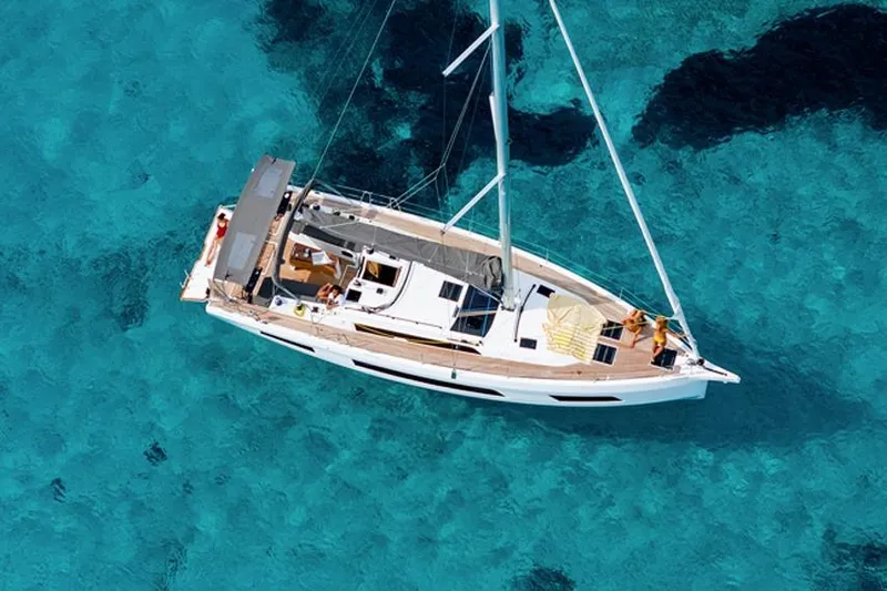  Yacht Photos Pics 2024 Dufour 44 yacht sailing on clear turquoise waters, aerial view.