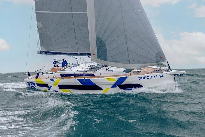  Yacht Photos Pics 2024 Dufour 44 sailboat navigating ocean waves under clear skies.