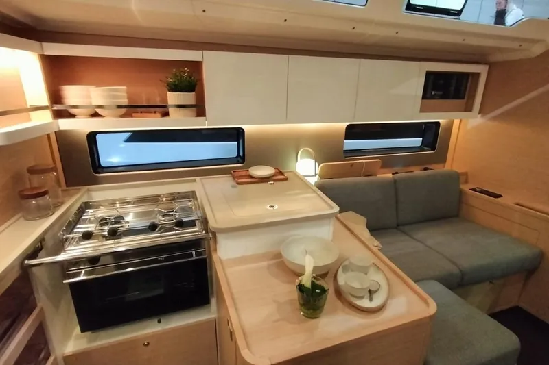  Yacht Photos Pics Modern interior of 2024 Dufour 44 yacht with kitchen and seating area.