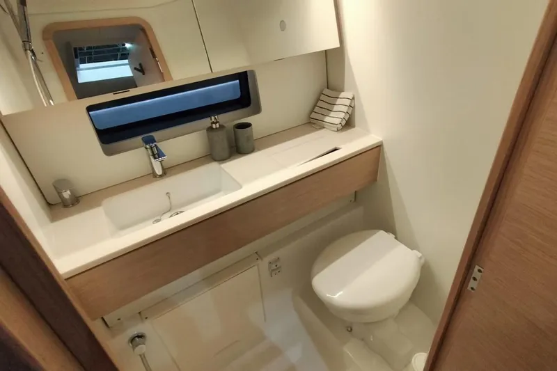  Yacht Photos Pics Modern bathroom interior of 2024 Dufour 44 yacht with sleek fixtures and window.