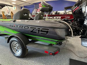 2025 Nitro Z19 boat with green accents on a trailer in a showroom.