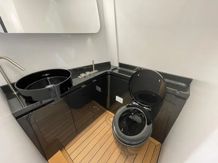 Sofia Yacht Photos Pics Luxurious bathroom in 2019 Maori 54 Open yacht with sleek black fixtures and wooden flooring.