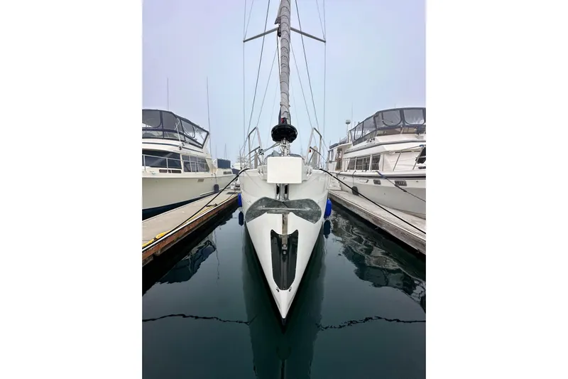 Pain Killer Yacht Photos Pics Bavaria C50 sailboat docked between yachts, 2020 model, in a marina setting.