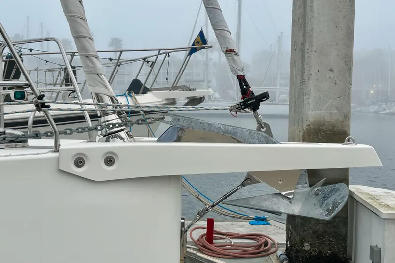Pain Killer Yacht Photos Pics Bavaria C50 yacht anchored at a foggy marina, showcasing anchor and rigging.