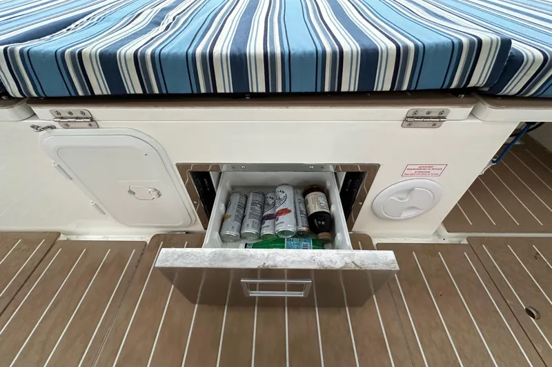 Pain Killer Yacht Photos Pics Bavaria C50 yacht with striped cushion and open drawer containing beverages, 2020 model.