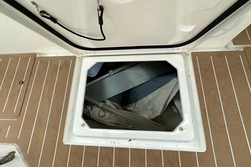 Pain Killer Yacht Photos Pics Open storage compartment on 2020 Bavaria C50 yacht deck, revealing interior contents.