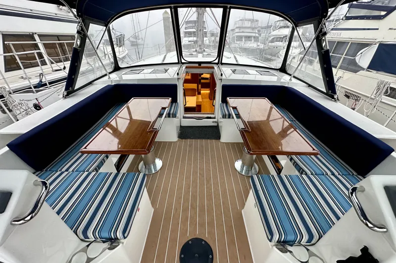 Pain Killer Yacht Photos Pics Spacious cockpit of 2020 Bavaria C50 yacht with striped seating and wooden tables.