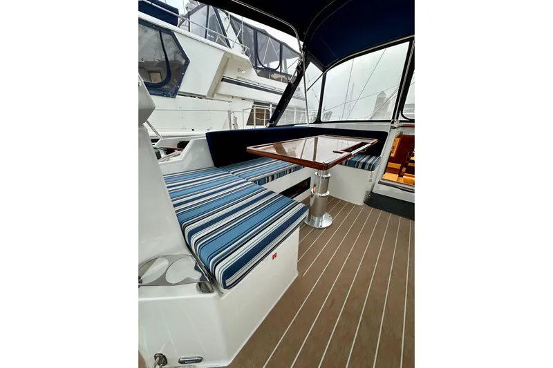 Pain Killer Yacht Photos Pics Interior of 2020 Bavaria C50 yacht with striped seating and wooden table.