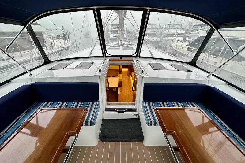 Pain Killer Yacht Photos Pics Interior view of 2020 Bavaria C50 yacht with elegant seating and wooden tables.