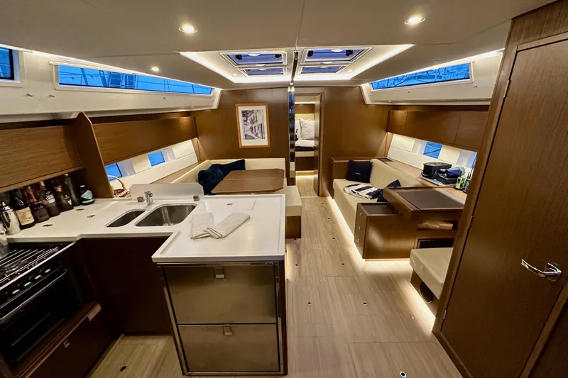 Pain Killer Yacht Photos Pics Luxurious interior of a 2020 Bavaria C50 yacht with modern kitchen and seating area.
