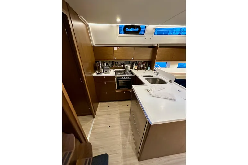 Pain Killer Yacht Photos Pics Modern kitchen interior of 2020 Bavaria C50 yacht with wooden cabinets and sleek countertops.