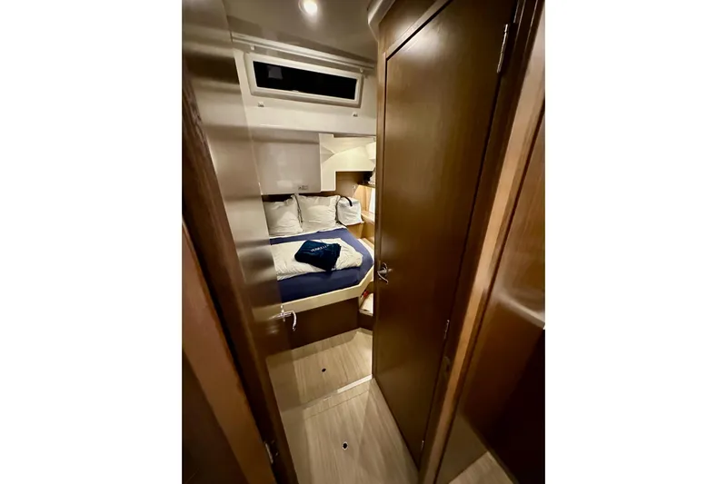 Pain Killer Yacht Photos Pics Interior cabin of 2020 Bavaria C50 yacht with cozy bed and wooden finish.