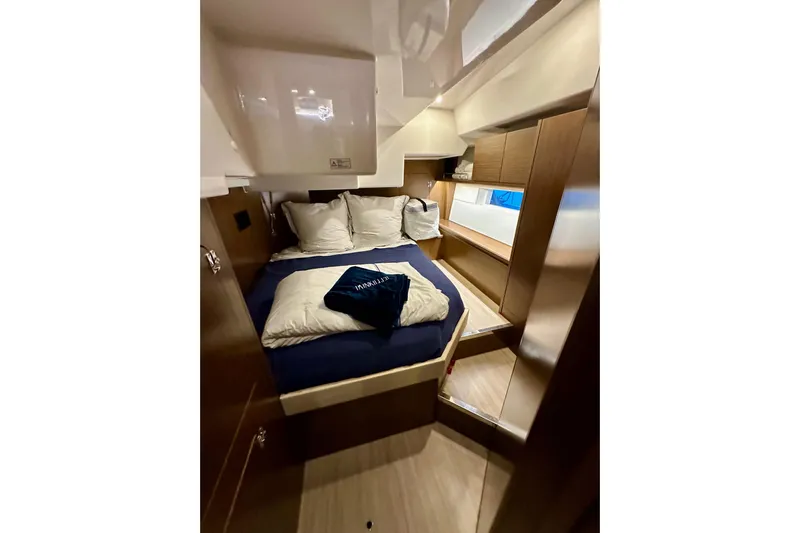 Pain Killer Yacht Photos Pics Luxurious cabin interior of 2020 Bavaria C50 yacht with cozy bedding and wooden finishes.