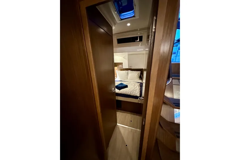Pain Killer Yacht Photos Pics Interior of 2020 Bavaria C50 yacht, featuring a cozy bedroom with wooden accents.