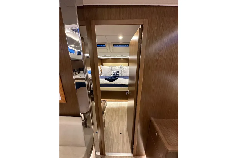 Pain Killer Yacht Photos Pics Interior view of 2020 Bavaria C50 yacht cabin with cozy bed and wooden finish.