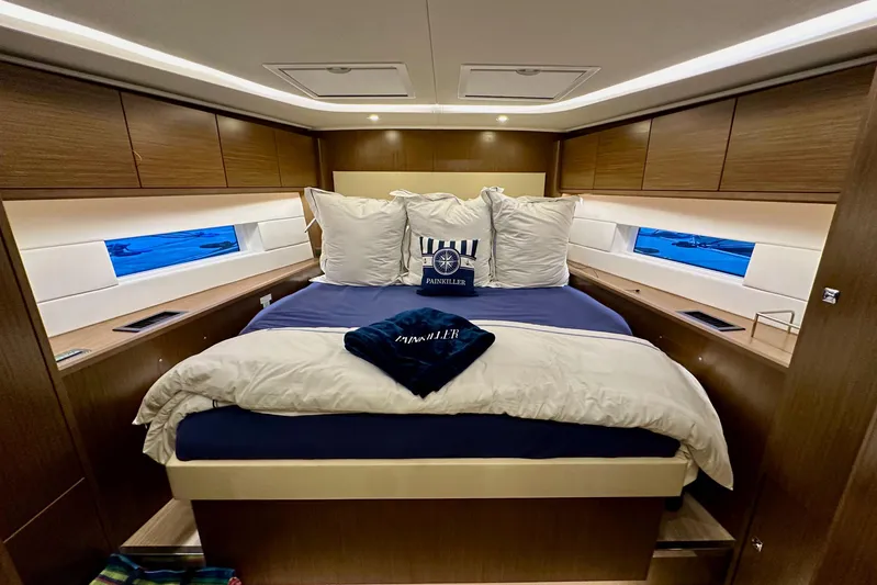 Pain Killer Yacht Photos Pics Luxurious cabin interior of 2020 Bavaria C50 yacht with cozy bedding and wooden finishes.