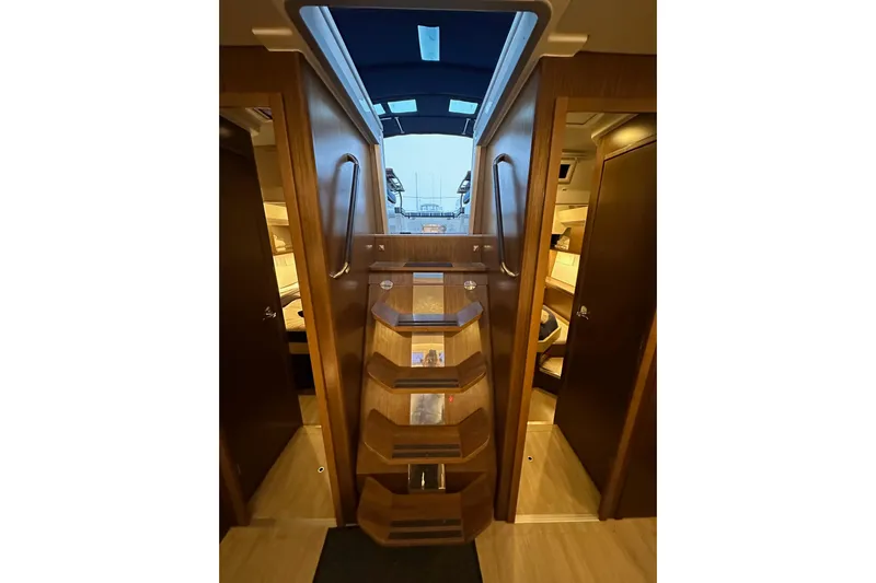 Pain Killer Yacht Photos Pics Interior view of 2020 Bavaria C50 yacht, featuring wooden stairs and cabin access.