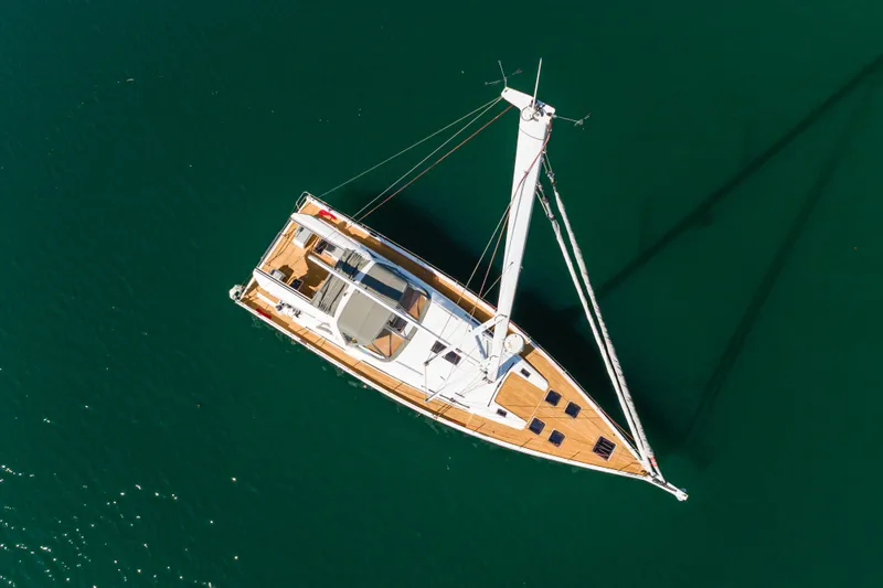 Joy Yacht Photos Pics Aerial view of 2023 Beneteau Oceanis Yacht 60 sailing on calm waters.