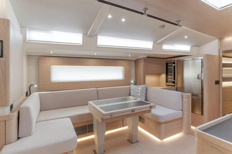 Joy Yacht Photos Pics Luxurious interior of 2023 Beneteau Oceanis Yacht 60 with modern seating and dining area.