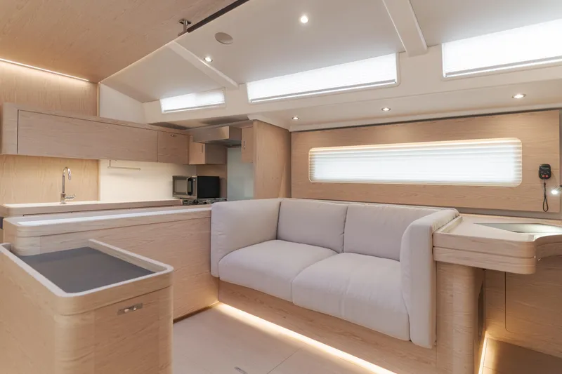 Joy Yacht Photos Pics Luxurious interior of 2023 Beneteau Oceanis Yacht 60, featuring modern kitchen and comfortable seating.