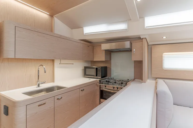 Joy Yacht Photos Pics Modern kitchen interior of 2023 Beneteau Oceanis Yacht 60 with sleek cabinetry and appliances.