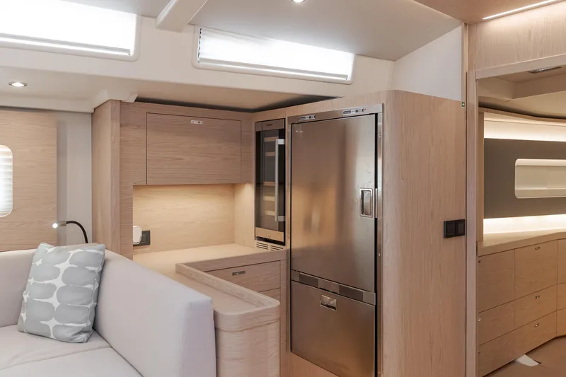 Joy Yacht Photos Pics Luxurious interior of 2023 Beneteau Oceanis Yacht 60, featuring modern kitchen and seating area.