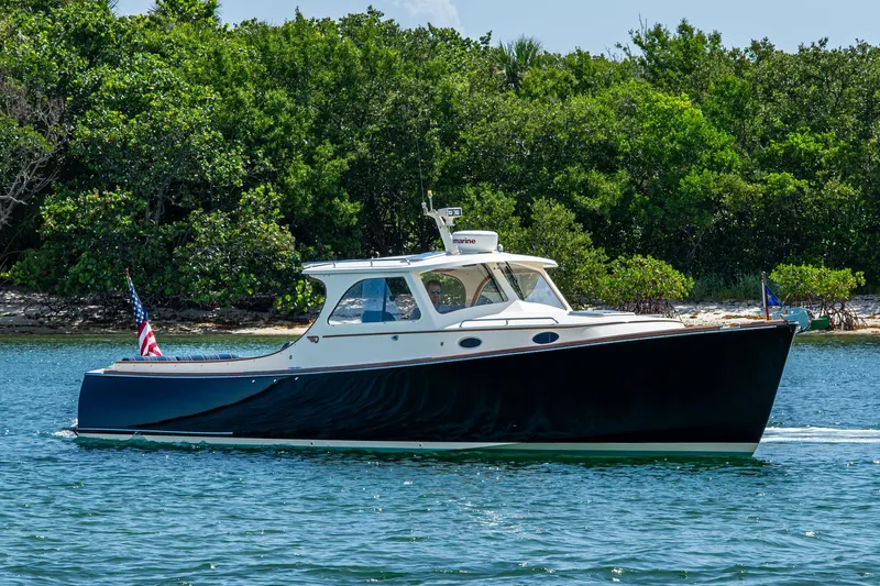 Summer Bliss Yacht Photos Pics 2001 Hinckley Picnic Boat Classic cruising on water near lush green shoreline.
