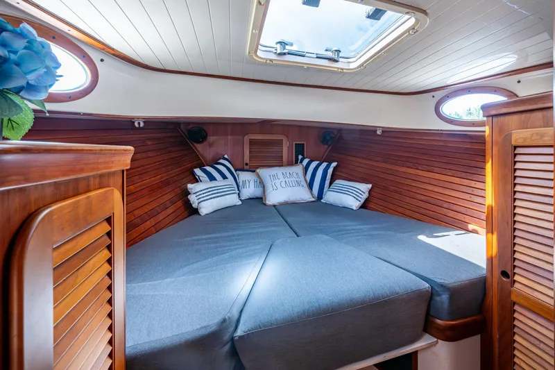 Summer Bliss Yacht Photos Pics Cozy cabin interior of 2001 Hinckley Picnic Boat Classic with wood paneling and cushions.