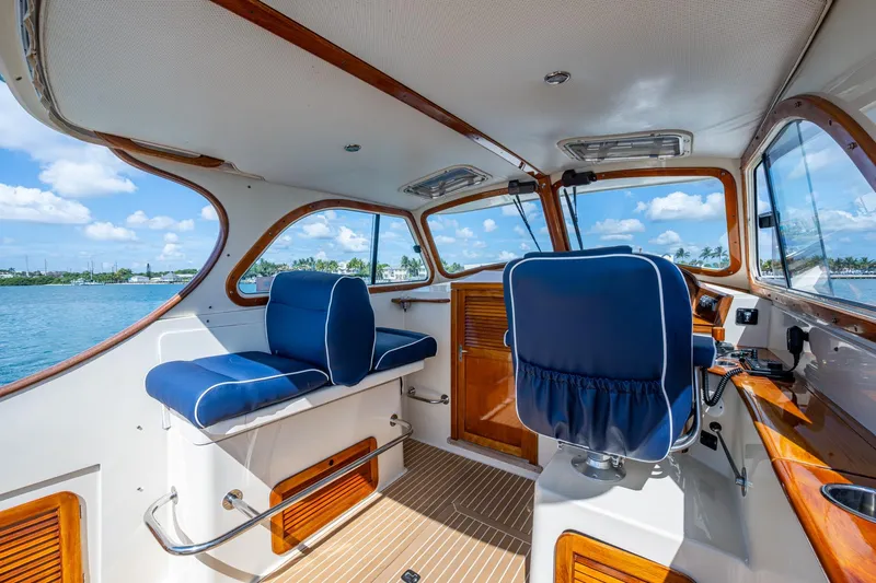 Summer Bliss Yacht Photos Pics Interior of 2001 Hinckley Picnic Boat Classic with blue seating and wooden accents.