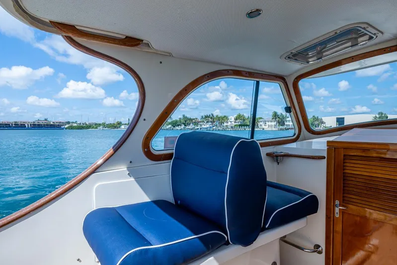 Summer Bliss Yacht Photos Pics Interior view of 2001 Hinckley Picnic Boat Classic with blue seating and scenic water backdrop.