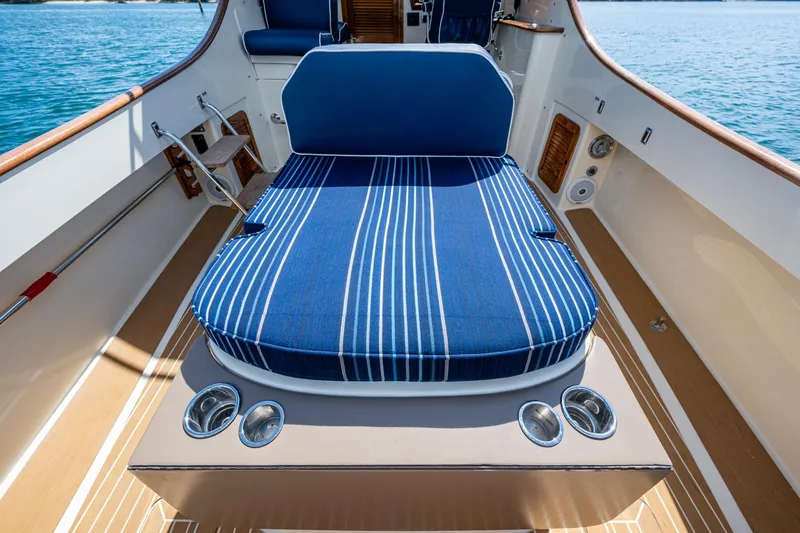 Summer Bliss Yacht Photos Pics 2001 Hinckley Picnic Boat Classic with blue striped seating on deck, ocean view.