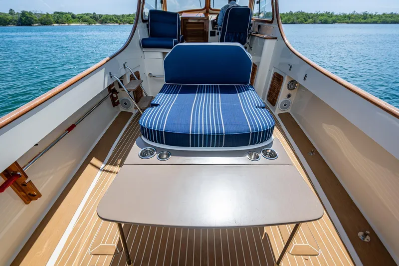 Summer Bliss Yacht Photos Pics 2001 Hinckley Picnic Boat Classic interior with striped seating and table on calm water.
